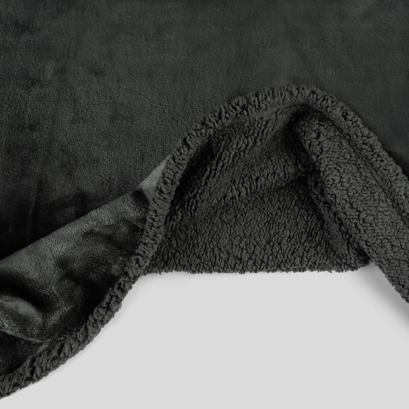 Waterproof blanket draped over the corner of a bed to protect the mattress from the wet spot